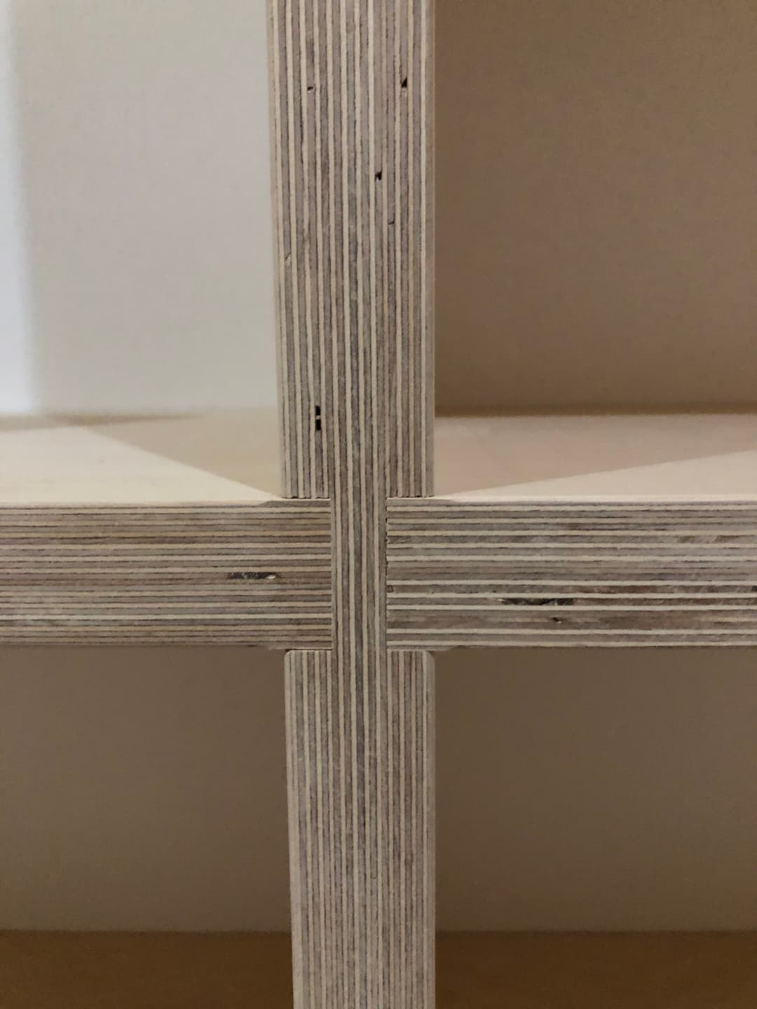 Intersecting wood layers of a modern shelf design showcasing craftsmanship and texture.