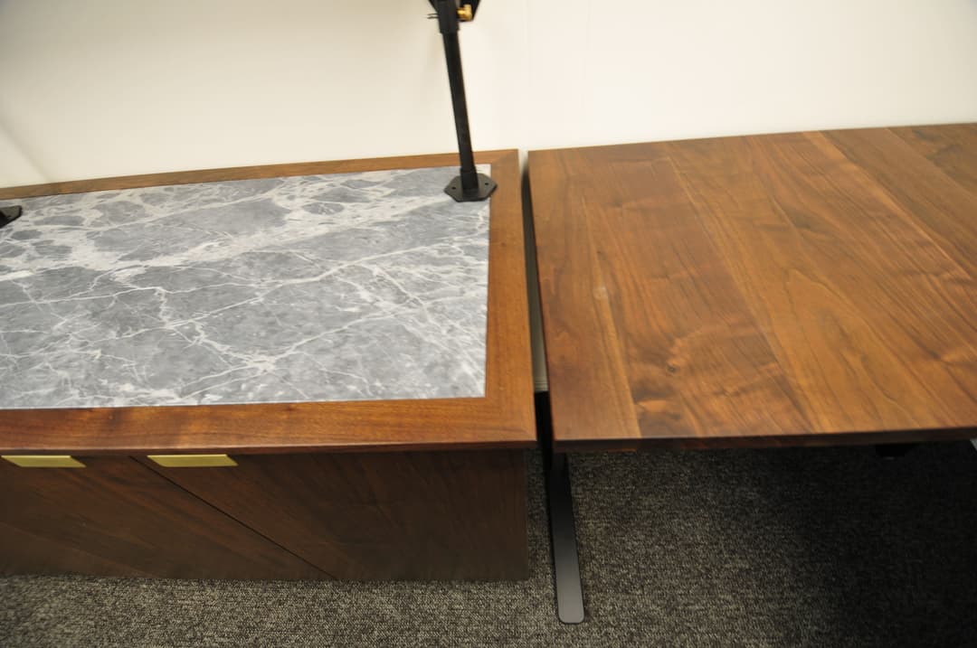 Modern office desk with marble and wooden surfaces, showcasing sleek design and functionality.