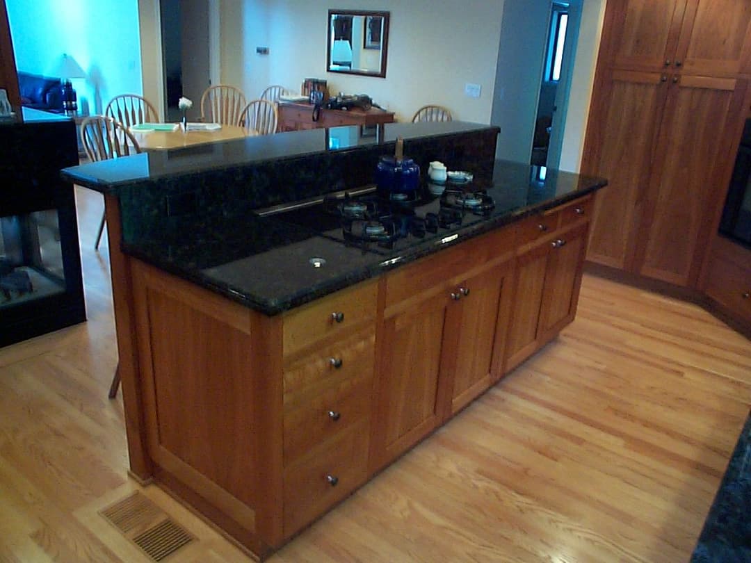 Modern kitchen with wooden cabinets, a black granite countertop, and a gas stove.
