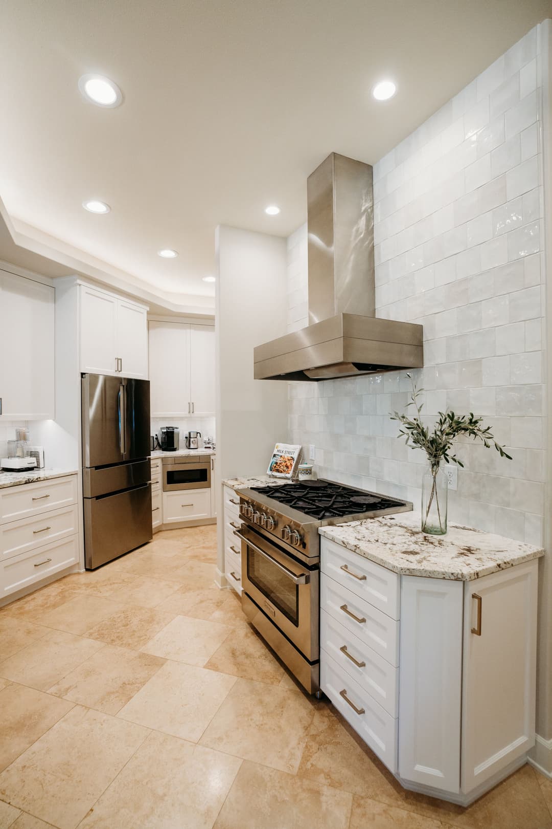 Modern kitchen with granite countertops, stainless steel appliances, and white cabinetry.