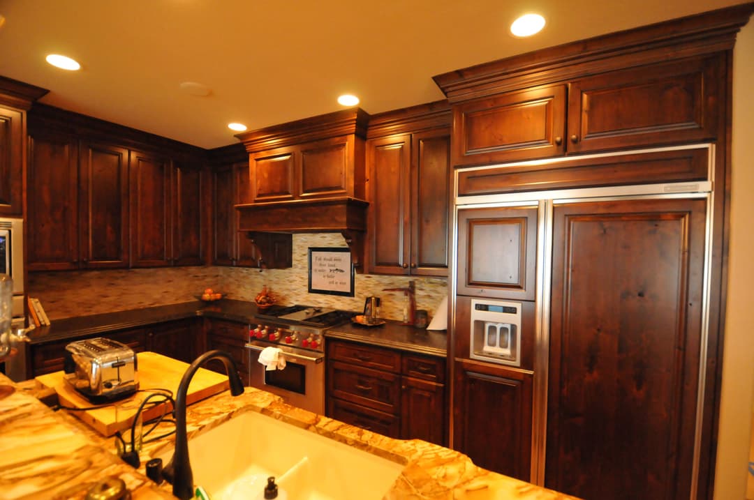 Elegant kitchen with dark wooden cabinets, granite countertops, and stainless steel appliances.