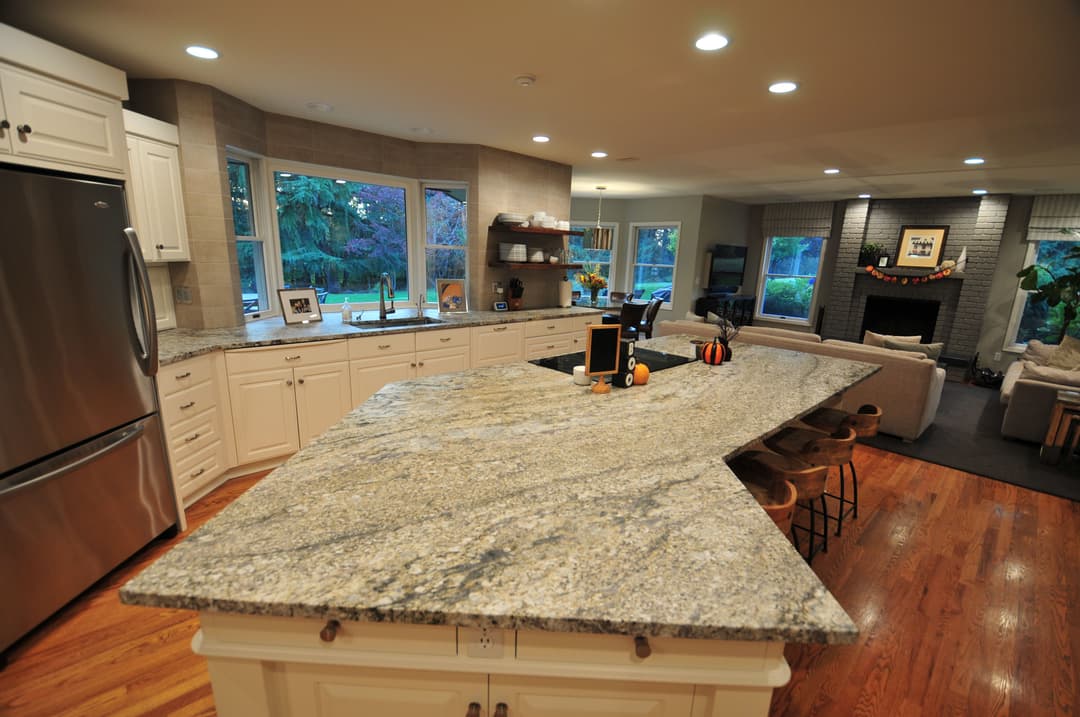 Modern kitchen with granite countertop, sleek cabinetry, and spacious layout featuring large windows.