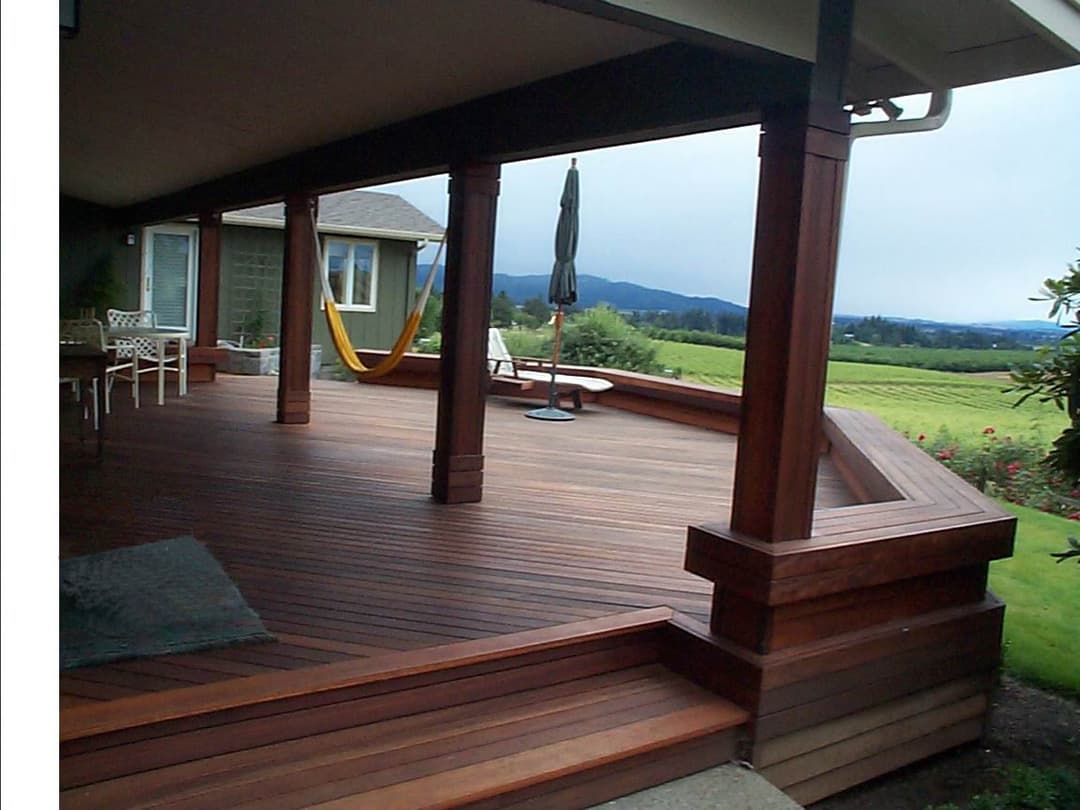 Spacious wooden deck with scenic mountain view, hammock, and outdoor furniture.