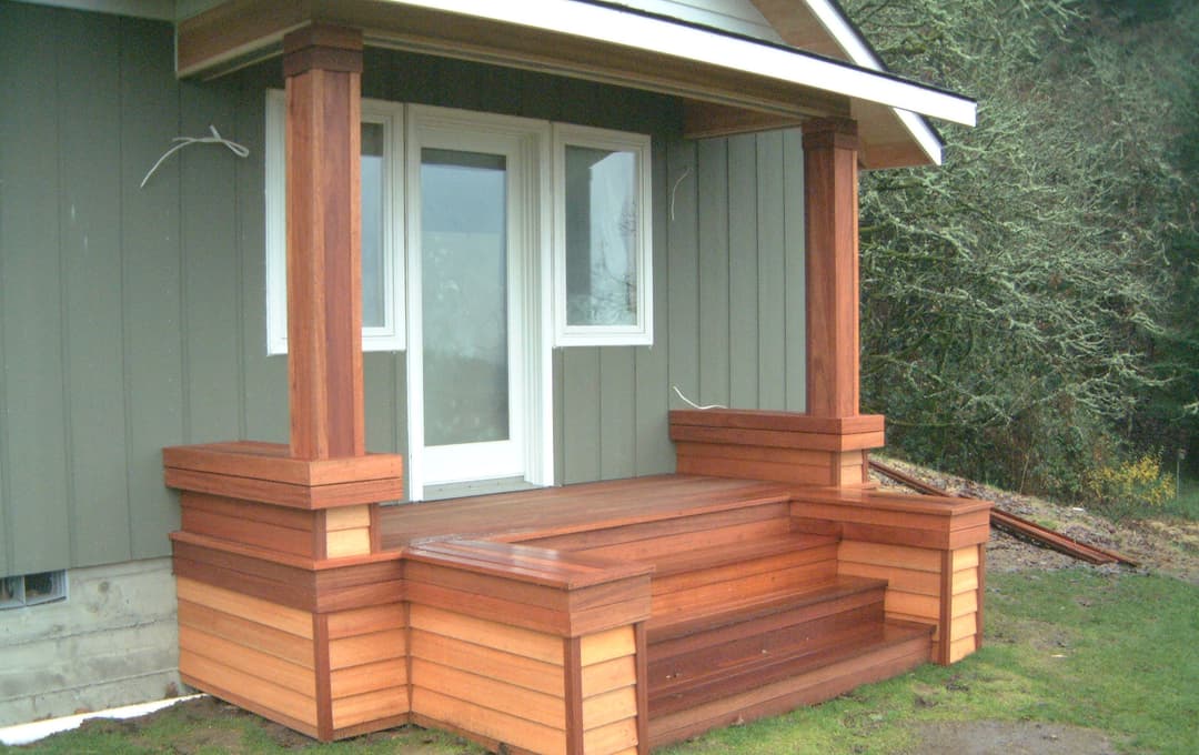Wooden front porch with steps and decorative posts, featuring a modern design and natural materials.