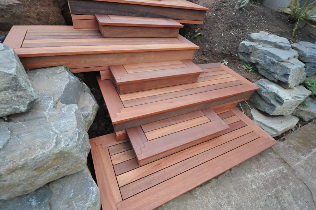 Stylish wooden steps integrated with stone landscaping for outdoor aesthetics.