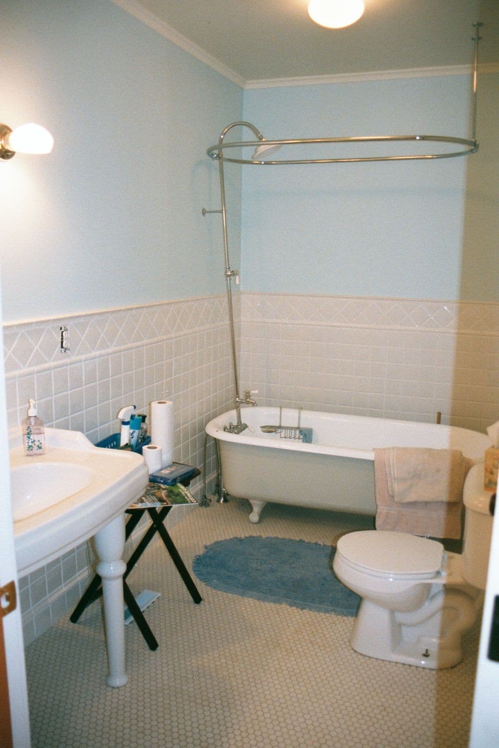 Bright and spacious bathroom featuring a bathtub, sink, and toilet with light blue walls.