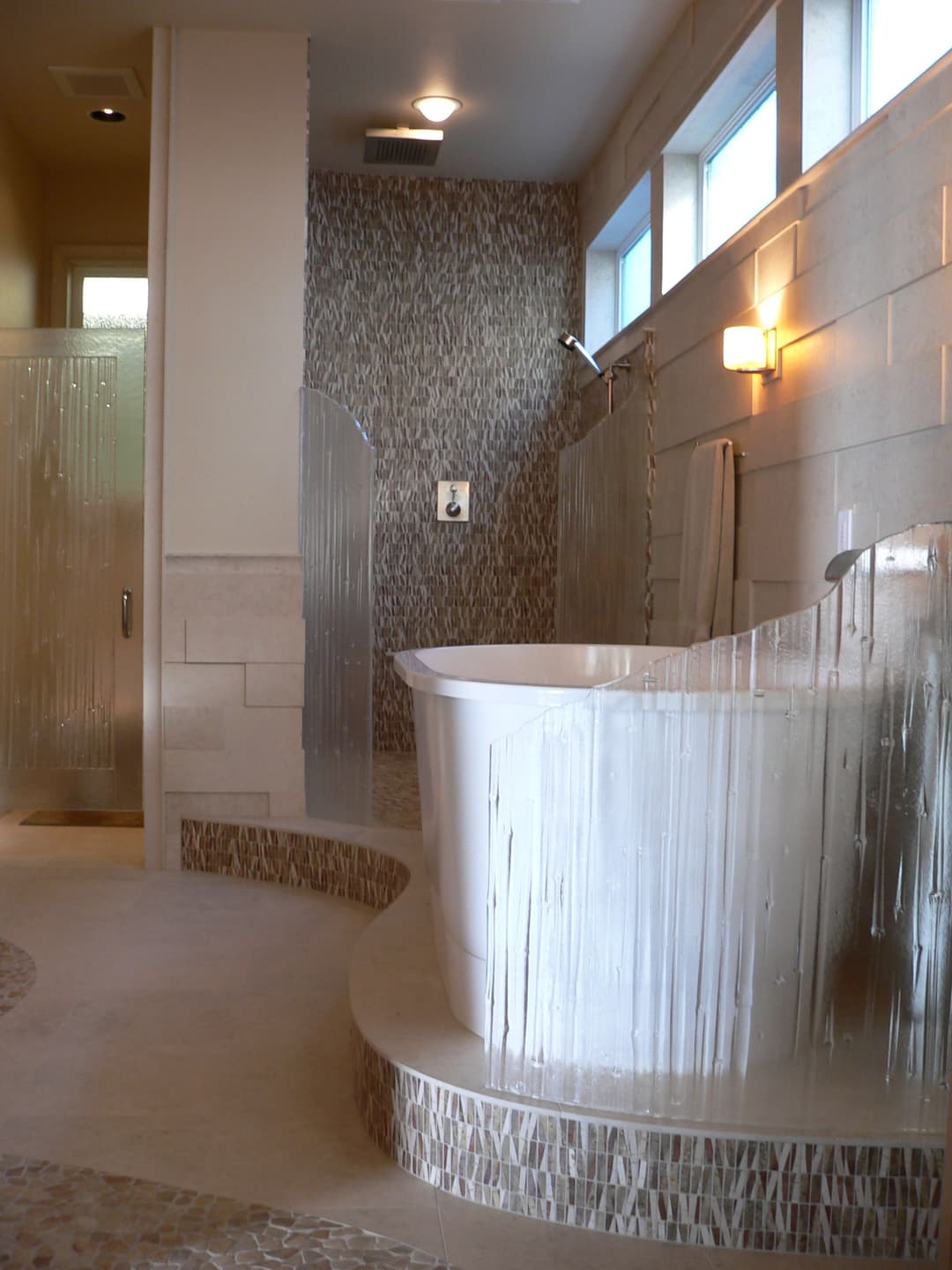 Modern bathroom featuring a freestanding tub, glass shower, and elegant tile design.