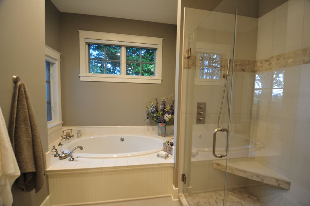Modern bathroom featuring a spacious soaking tub, glass shower, and elegant decor.