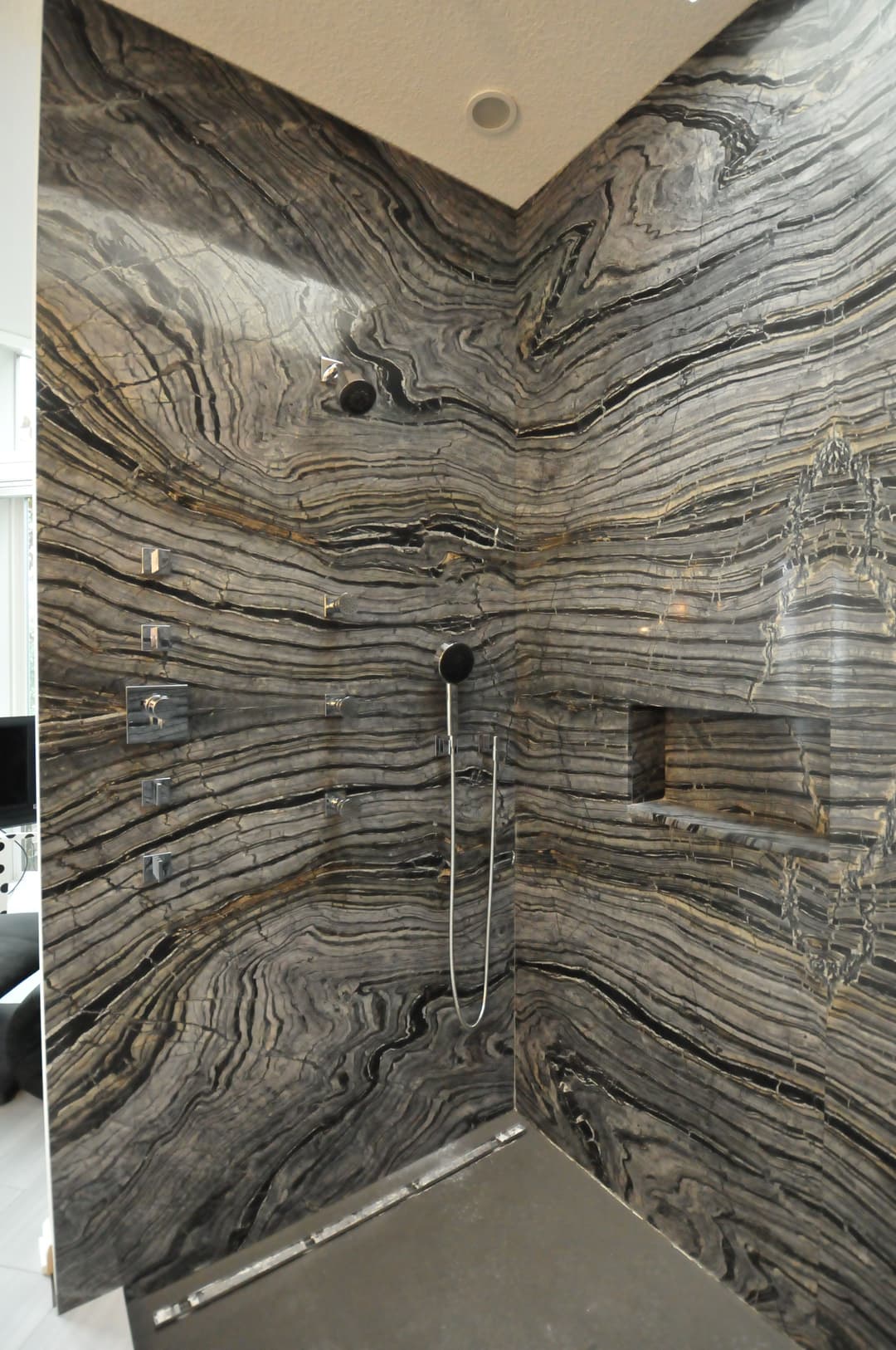 Luxurious modern shower with stunning marble walls and sleek fixtures.