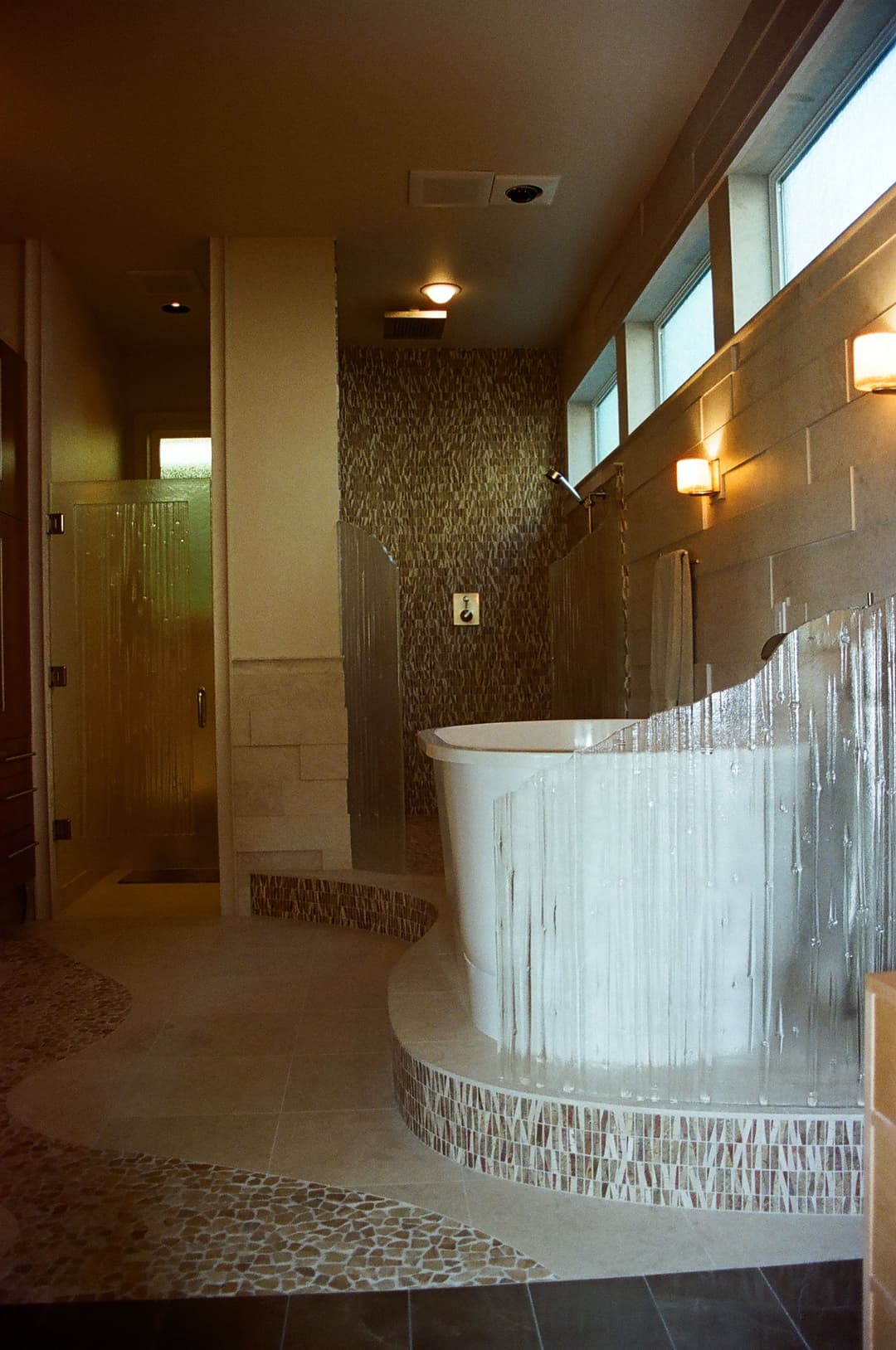 Modern bathroom featuring a freestanding tub, spacious shower, and decorative tile accents.