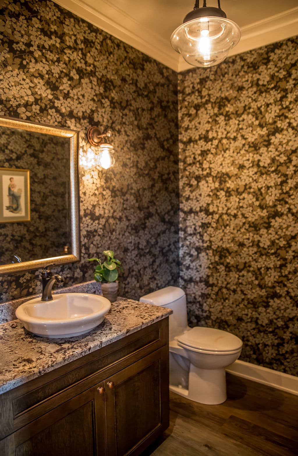 Elegant bathroom with floral wallpaper, granite countertop, mirror, and modern toilet.