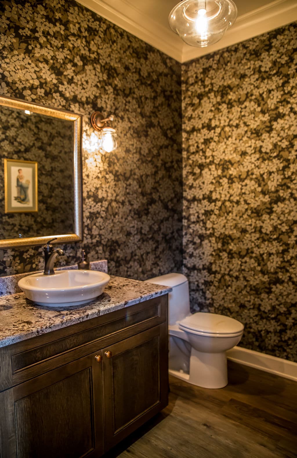 Elegant bathroom featuring floral wallpaper, granite sink, and classic fixtures.