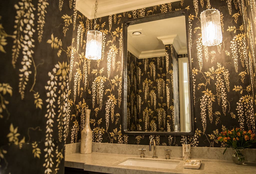 Elegant bathroom with floral wallpaper, modern lighting, and stylish sink area.