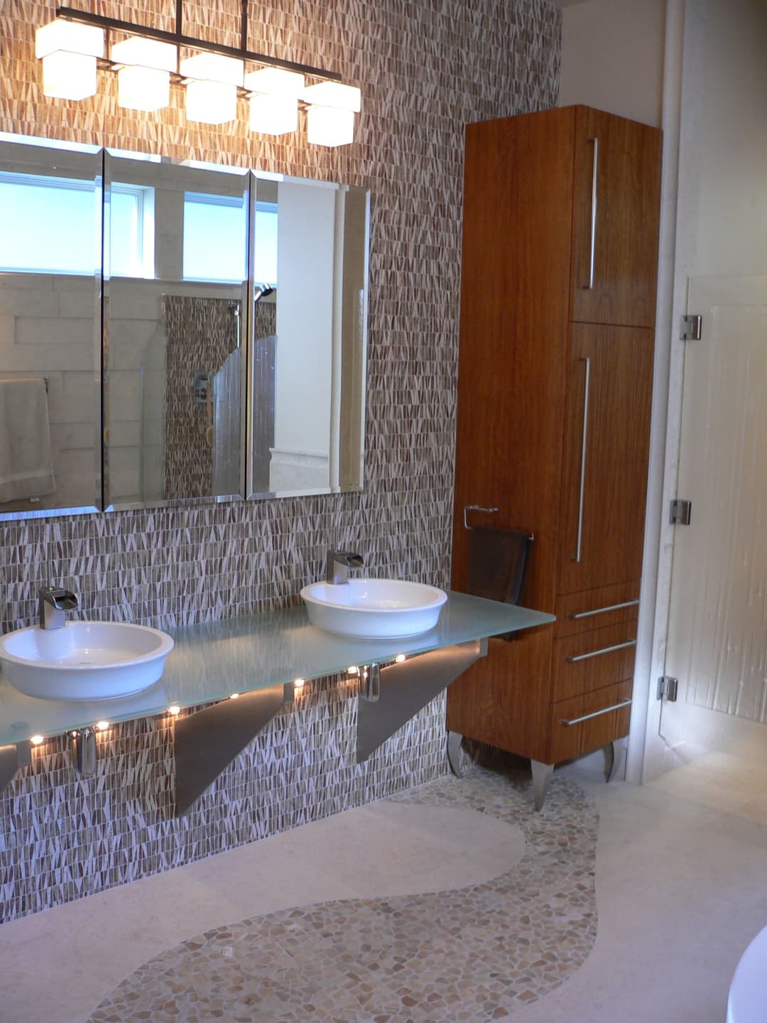Modern bathroom design featuring dual sinks, contemporary lighting, and textured wall.