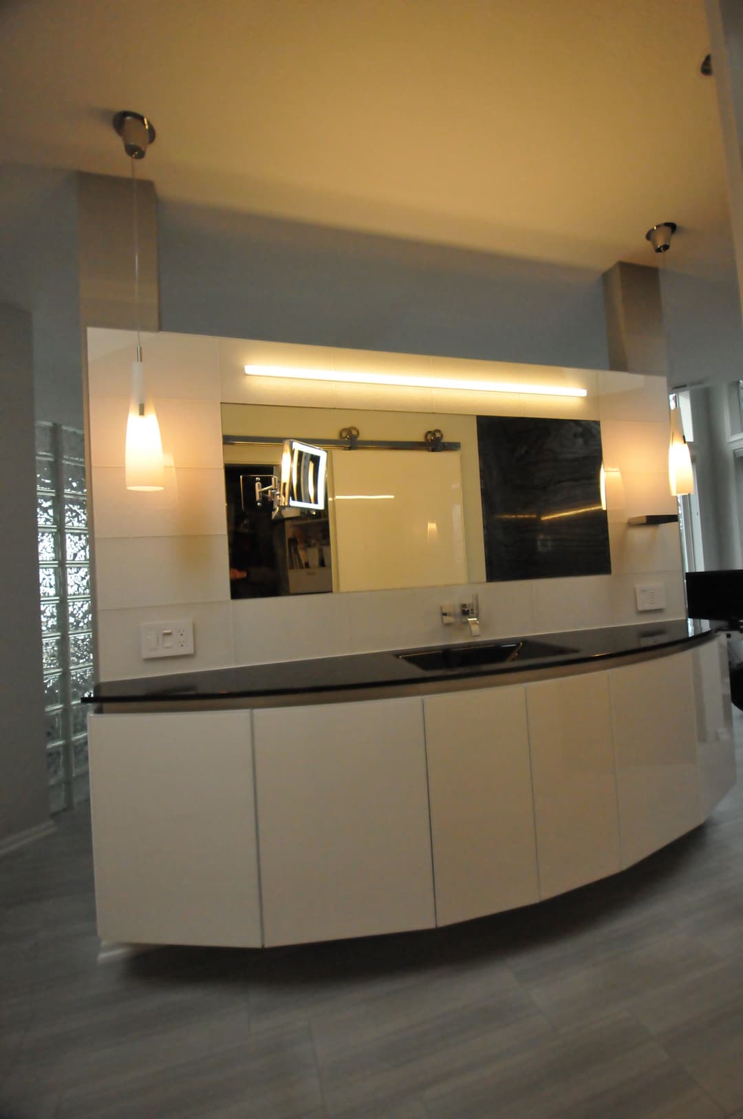 Modern bathroom vanity with sleek design, overhead lighting, and stylish mirror display.