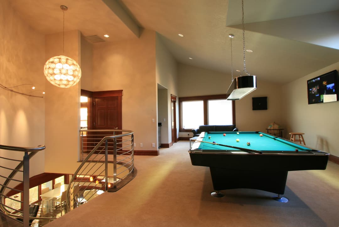 Contemporary game room featuring a billiards table, elegant lighting, and modern decor.