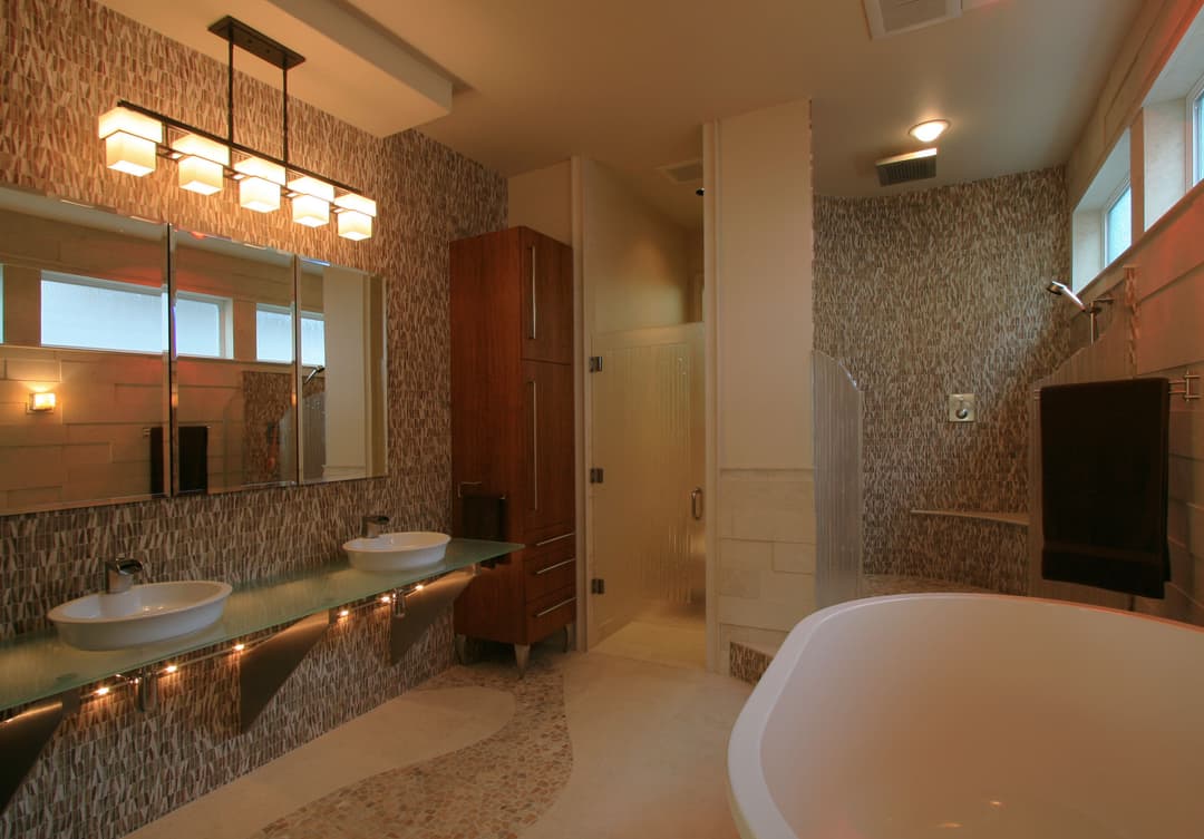 Modern bathroom with dual sinks, glass shower, and elegant lighting. Relaxing spa-like atmosphere.