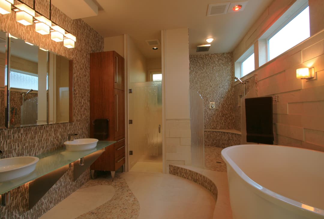 Modern bathroom design featuring a glass shower, freestanding tub, and dual sinks with stylish decor.