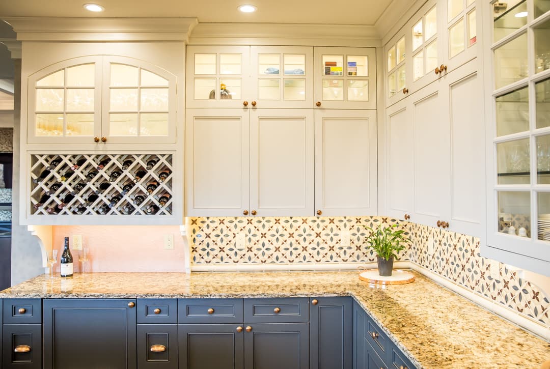 Modern kitchen with blue cabinetry, granite countertops, and decorative tile backsplash.