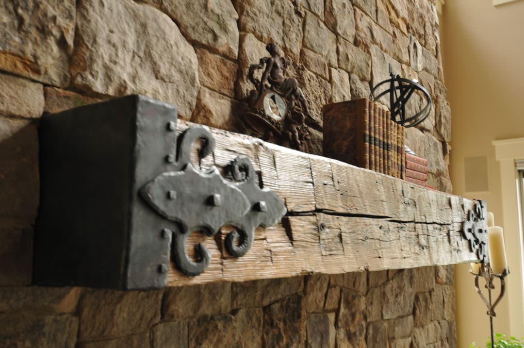 Rustic wooden shelf with decorative clock, books, and an orb on a stone wall.