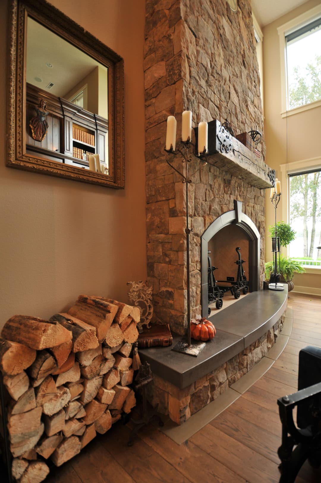 Cozy living room with stone fireplace, wood stack, and elegant decor highlights warmth and style.