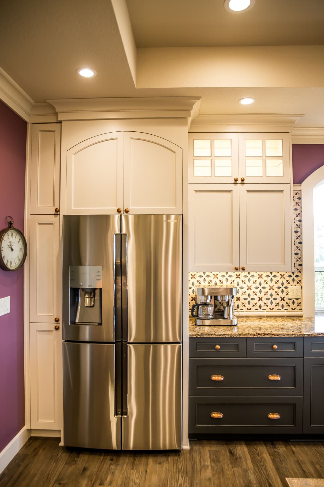 Modern kitchen featuring a stainless steel refrigerator, stylish cabinetry, and granite countertops.