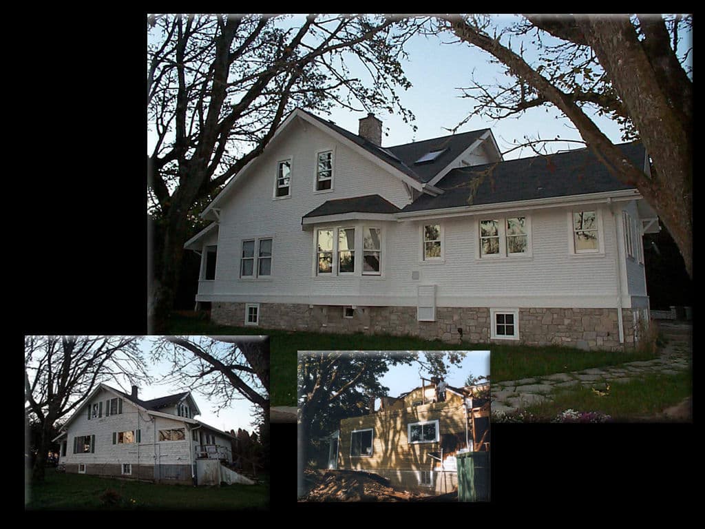 Historic white farmhouse with stone accents, surrounded by trees and showcasing renovation details.