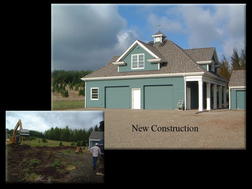 Newly constructed house with a spacious garage and construction site visible in the background.