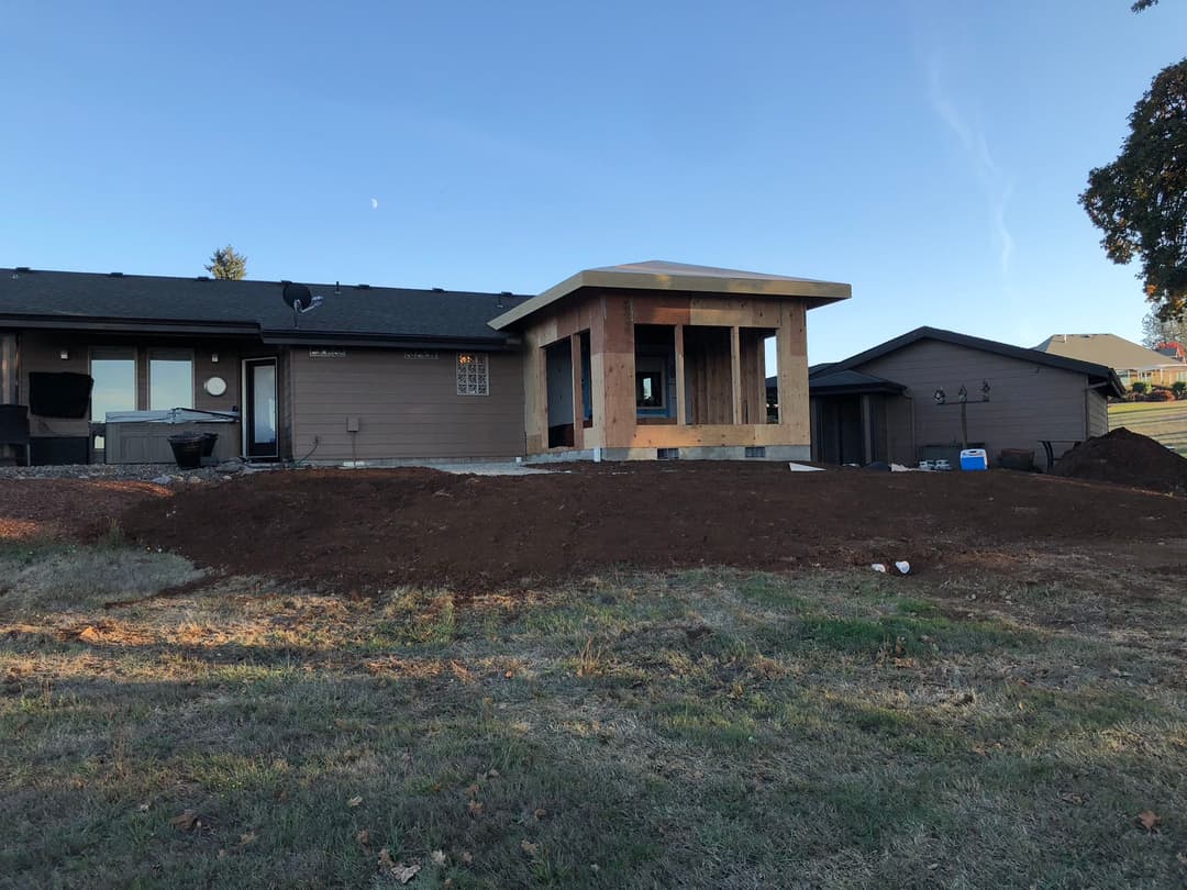 Home renovation project featuring a new addition under construction on a sunny day.