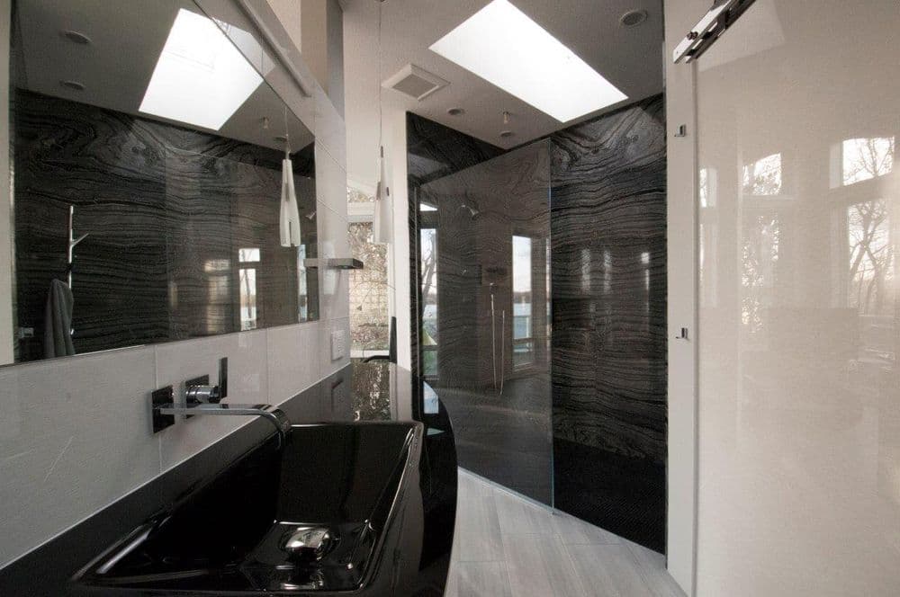 Modern bathroom with black marble features, sleek black sink, and minimalist design elements.
