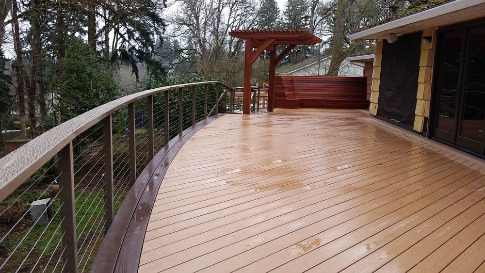 Modern curved wooden deck with railing, showcasing a serene outdoor space.