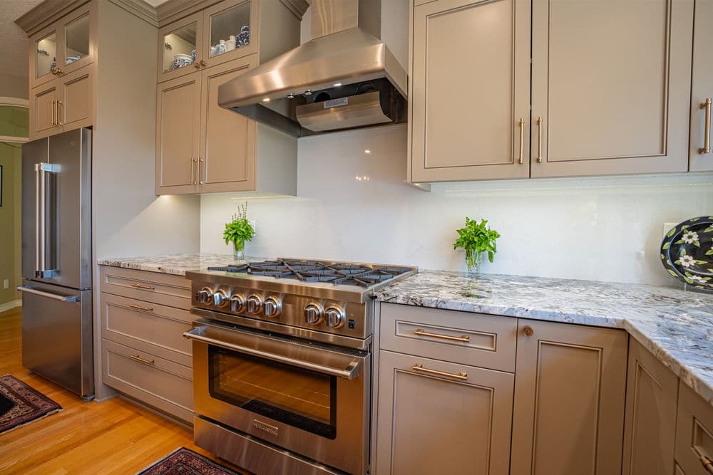 Modern kitchen with stainless steel appliances, granite countertops, and elegant cabinetry.