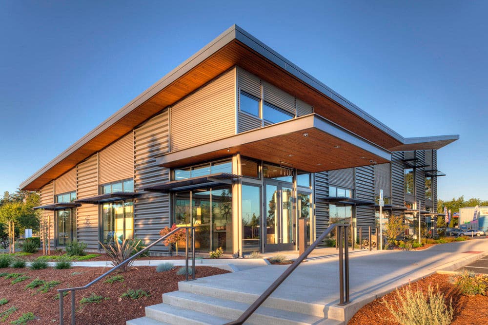 Modern architectural building with large glass windows and a distinctive angled roof design.