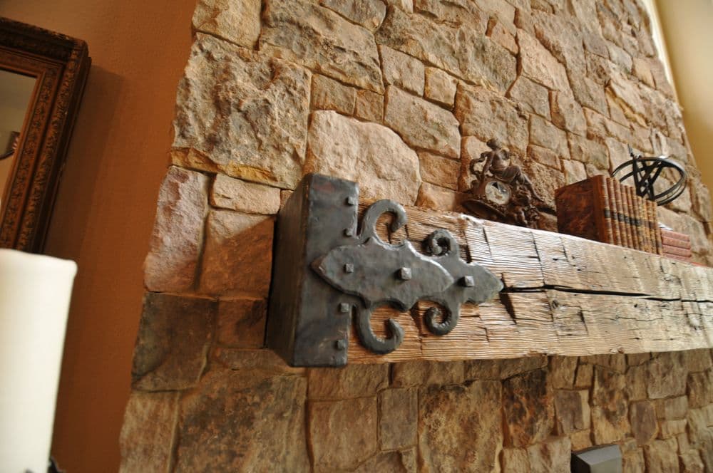 Rustic stone fireplace with a decorative wooden mantel and vintage artifacts.