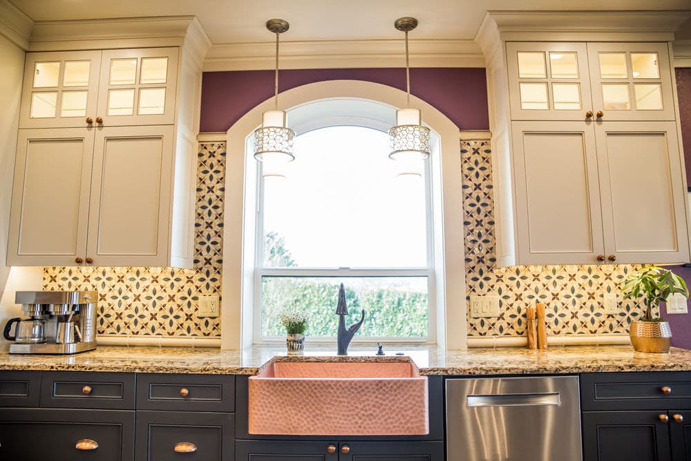 Modern kitchen with granite countertops, under-cabinet lighting, and a stylish copper sink.
