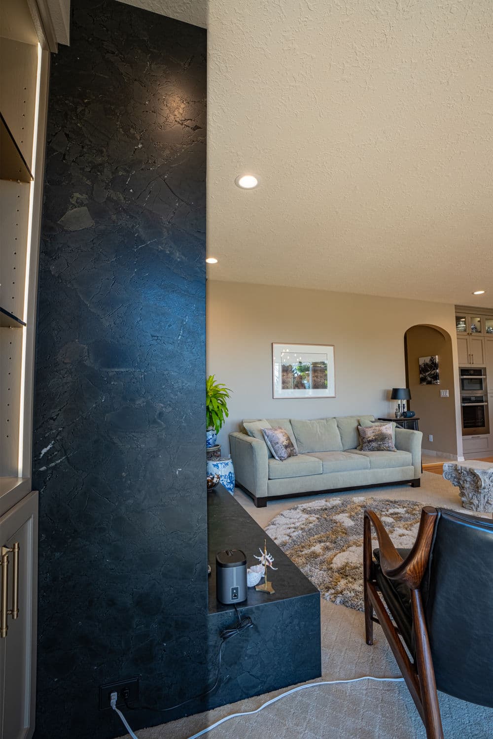 Modern living room featuring a stylish black accent wall and comfortable light-colored furniture.