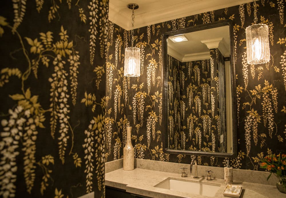 Elegant bathroom with floral wallpaper, marble sink, and stylish lighting fixtures.